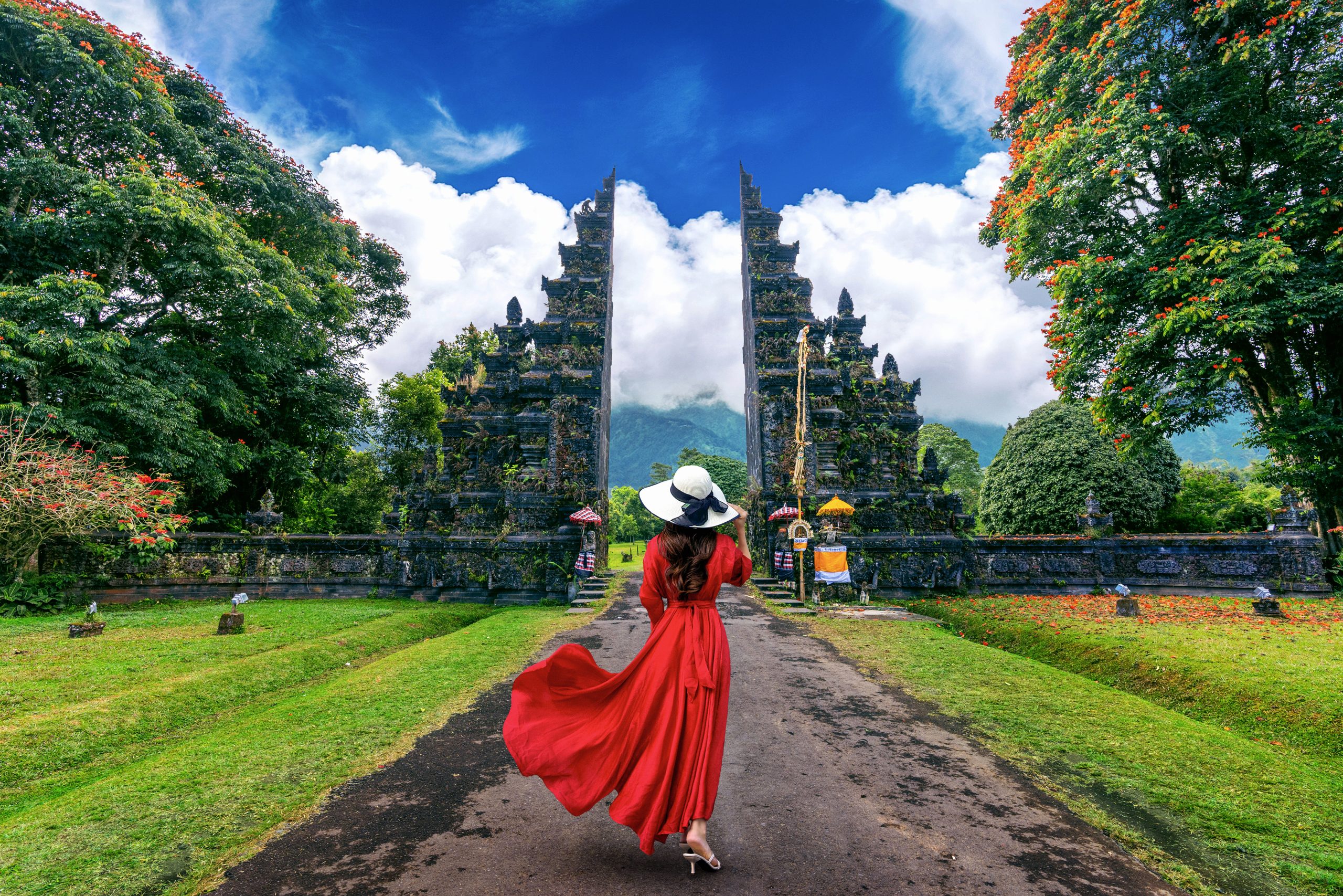 Woman walking at big entrance gate, Bali in Indonesia.